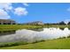 A picturesque pond reflects the sky and nearby homes, enhancing the natural beauty of the community at 3528 Maple Grove Way, Plant City, FL 33565