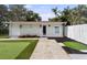 Charming backyard cottage with artificial turf, flower bed, and concrete walkway at 4002 W Watrous Ave, Tampa, FL 33629