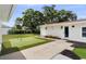 Backyard cottage with artificial turf, flower bed, and concrete walkway at 4002 W Watrous Ave, Tampa, FL 33629