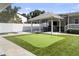 Beautiful backyard featuring a putting green, covered patio, outdoor furniture, and entertainment space at 4002 W Watrous Ave, Tampa, FL 33629