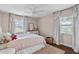 Cozy bedroom featuring wood floors, ceiling fan, and neutral color scheme at 4002 W Watrous Ave, Tampa, FL 33629