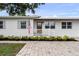 Inviting front porch with brick walkway, white railings, and lush landscaping at 4002 W Watrous Ave, Tampa, FL 33629