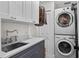 Well-organized laundry room with modern washer and dryer, gray cabinets, and sink at 4002 W Watrous Ave, Tampa, FL 33629