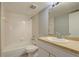 Bathroom with neutral countertop vanity, mirror and white-tiled shower at 4014 Ashford Green Pl # G103, Tampa, FL 33613