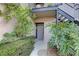 Neutral colored entrance with iron staircases on either side and lush plantings surrounding the front door at 4014 Ashford Green Pl # G103, Tampa, FL 33613
