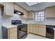 Functional kitchen featuring wooden cabinets, black appliances, and ample counter space for meal preparation at 4014 Ashford Green Pl # G103, Tampa, FL 33613