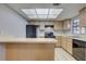 Efficient kitchen featuring ample cabinet space, black appliances, and a breakfast bar for casual dining at 4014 Ashford Green Pl # G103, Tampa, FL 33613