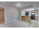 Open floor plan with a view of the kitchen featuring wood cabinets, breakfast bar, and black appliances at 4014 Ashford Green Pl # G103, Tampa, FL 33613