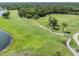 Picturesque aerial view of golf course featuring lush green fairways and mature trees with a water feature at 4211 Elba Pl, Valrico, FL 33596
