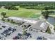 Aerial view of golf course and clubhouse surrounded by a parking lot and lush greenery at 4211 Elba Pl, Valrico, FL 33596