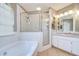 Bright bathroom featuring soaking tub, glass enclosed shower, and granite vanity at 4211 Elba Pl, Valrico, FL 33596