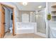 Bright bathroom featuring soaking tub, glass enclosed shower, and ceramic tile at 4211 Elba Pl, Valrico, FL 33596