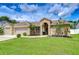 Charming brick home with a well-manicured lawn, mature landscaping, and an inviting arched entryway at 4211 Elba Pl, Valrico, FL 33596