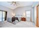 Airy main bedroom with vaulted ceiling, large bed, and a sliding glass door to a balcony at 4211 Elba Pl, Valrico, FL 33596