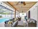 Inviting covered outdoor living area with comfortable seating and ceiling fans, next to a sparkling pool at 4211 Elba Pl, Valrico, FL 33596
