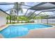 Inviting pool area enclosed by a screen, set against a backdrop of lush greenery and clear skies at 4211 Elba Pl, Valrico, FL 33596