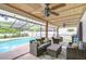 Inviting covered patio with comfortable seating area, ceiling fans, overlooking a sparkling swimming pool at 4211 Elba Pl, Valrico, FL 33596