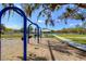 Community swings with a playground and walking path in the background with beautiful mature trees at 4211 Elba Pl, Valrico, FL 33596