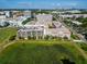 Aerial view featuring the building with parking garage, a pond, surrounding landscape, and distant city skyline at 4221 W Spruce St # 2218, Tampa, FL 33607