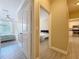 Hallway with tiled floor leading to bedroom and kitchen with white cabinets and stainless steel appliances at 4221 W Spruce St # 2218, Tampa, FL 33607