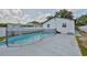 Fenced in Kidney-shaped pool in a backyard setting surrounded by lush green grass and shade trees at 4489 57Th N Ave, St Petersburg, FL 33714