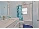 Bright bathroom with white marble wall tiles, modern vanity, tub, and stylish, leafy shower curtain at 4489 57Th N Ave, St Petersburg, FL 33714