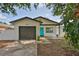 Charming single-story home with a gray garage door and bright turquoise front door at 4489 57Th N Ave, St Petersburg, FL 33714