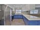 Open layout kitchen with blue cabinets, stainless steel appliances, and updated backsplash at 4489 57Th N Ave, St Petersburg, FL 33714
