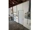 A garage boasts exposed rafters, concrete floor, a utility door and water heater, offering a functional space at 467 34Th N Ave, St Petersburg, FL 33704