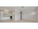Well-lit living space with adjacent kitchen featuring white cabinets and neutral tile flooring at 5262 25Th N Ave, St Petersburg, FL 33710