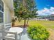 Well-maintained backyard featuring a manicured lawn, lush landscaping, and a covered seating area at 5755 Yorkshire Dr, Zephyrhills, FL 33542