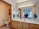 Well-lit bathroom with wood cabinets and a clear view of the main bedroom at 5755 Yorkshire Dr, Zephyrhills, FL 33542