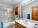 Neutral bathroom with a glass-enclosed shower, ample lighting, and a wood cabinet at 5755 Yorkshire Dr, Zephyrhills, FL 33542