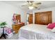 Comfortable bedroom featuring a ceiling fan, wood closet doors, and neutral carpeting at 5755 Yorkshire Dr, Zephyrhills, FL 33542