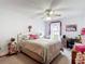 Cozy bedroom featuring a ceiling fan, comfortable bedding, and a desk at 5755 Yorkshire Dr, Zephyrhills, FL 33542