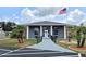 Inviting clubhouse entrance with an American flag and decorative planters at 5755 Yorkshire Dr, Zephyrhills, FL 33542