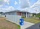Charming single-story home with a combination of gray stucco and brick exterior, complemented by manicured landscaping and clear skies at 5755 Yorkshire Dr, Zephyrhills, FL 33542