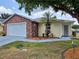 Charming single-story home showcasing a brick facade, manicured landscaping, and a two-car garage at 5755 Yorkshire Dr, Zephyrhills, FL 33542