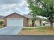 Charming single-story home showcasing a brick facade, manicured landscaping, and a two-car garage at 5755 Yorkshire Dr, Zephyrhills, FL 33542