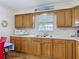 Classic kitchen with hardwood floors, wooden cabinets, and double sink at 5755 Yorkshire Dr, Zephyrhills, FL 33542