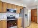 Well-equipped kitchen with stainless steel appliances and wooden cabinetry at 5755 Yorkshire Dr, Zephyrhills, FL 33542