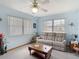 Bright living room with large windows, ceiling fan, and neutral-colored sofa at 5755 Yorkshire Dr, Zephyrhills, FL 33542