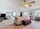 Spacious living room with neutral tones, carpet, and multiple ceiling fans at 5755 Yorkshire Dr, Zephyrhills, FL 33542