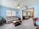 Spacious living room with light blue walls, ceiling fan, and comfortable seating arrangement at 5755 Yorkshire Dr, Zephyrhills, FL 33542