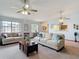 Spacious living room with neutral-toned furniture, ceiling fans, and a large window at 5755 Yorkshire Dr, Zephyrhills, FL 33542