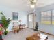 Bright living room with light blue walls, featuring a ceiling fan and a front door at 5755 Yorkshire Dr, Zephyrhills, FL 33542