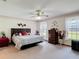 Comfortable main bedroom featuring a ceiling fan, carpeted floors, and large windows at 5755 Yorkshire Dr, Zephyrhills, FL 33542