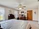 Spacious main bedroom with a ceiling fan, large windows, and an ensuite bathroom at 5755 Yorkshire Dr, Zephyrhills, FL 33542