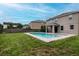 Backyard view featuring a sparkling pool, well-kept lawn, and covered patio at 5916 Tulip Flower Dr, Riverview, FL 33578