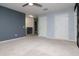 Bedroom with neutral carpet, ceiling fan, large closet, and view of the hallway at 5916 Tulip Flower Dr, Riverview, FL 33578